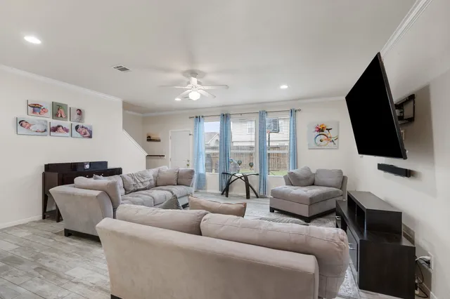 a living room with furniture a flat screen tv and a large window