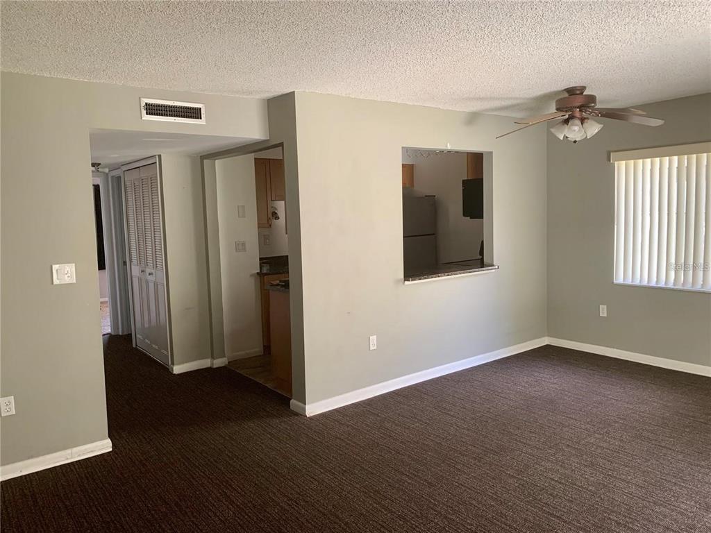 525 South Conway Road, Unit 189D Orlando, FL 32807 - Photo 4 of 19 an empty room with wooden floor and windows