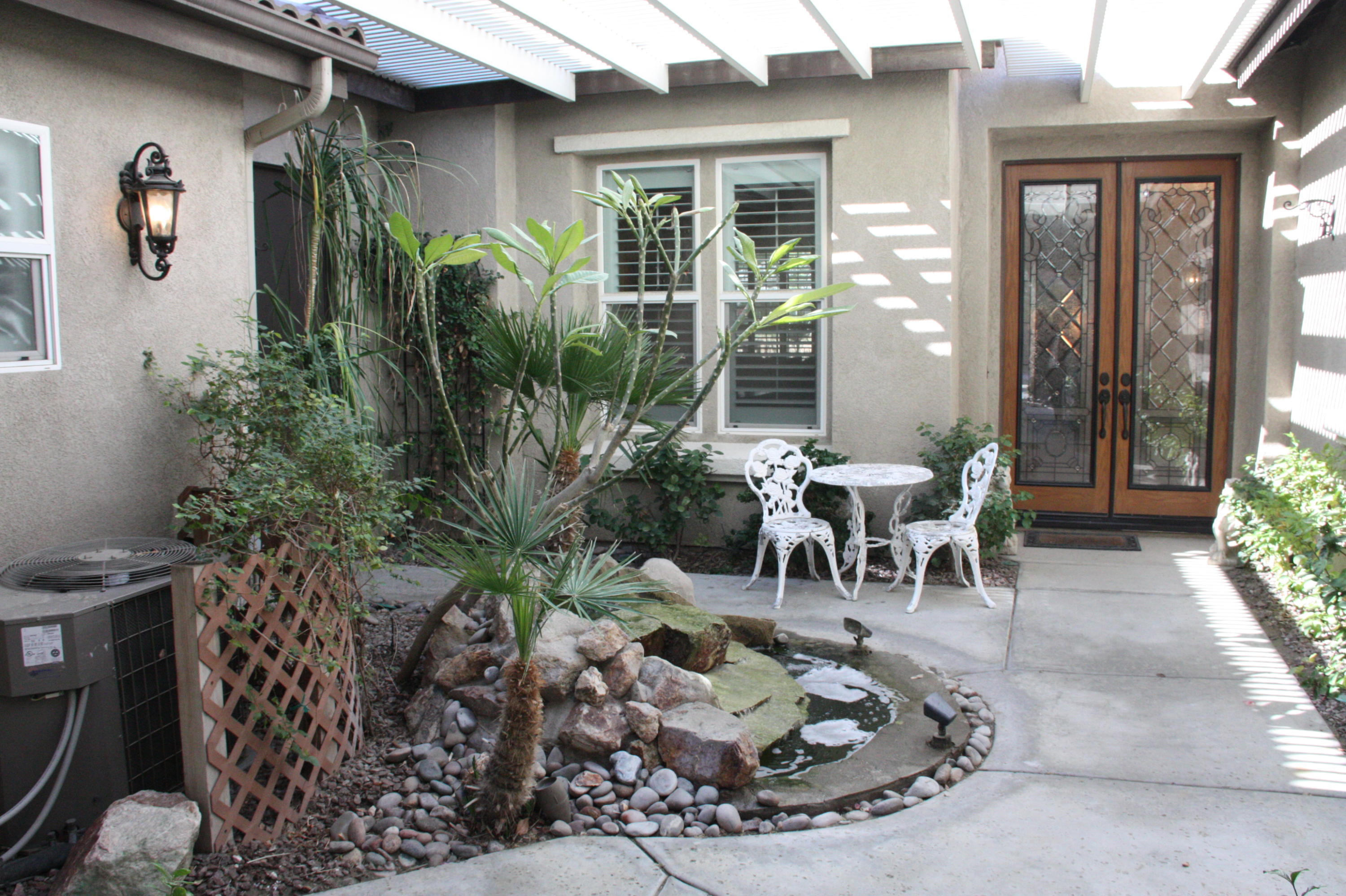 49475 Redford Way Indio, CA 92201 - Photo 4 of 58 a view of a patio with table and chairs and potted plants