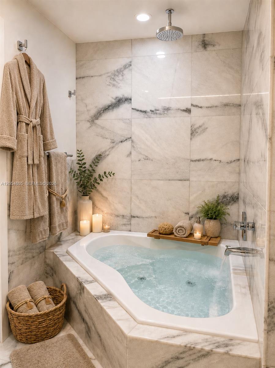 3538 Southwest 1st Avenue, Unit 1 Miami, FL 33145 - Photo 5 of 20 Spa-inspired master bathroom featuring a jetted soaking tub surrounded by marble-style tile, a ceiling-mounted rainfall showerhead, polished chrome fixtures, and recessed lighting. The bright, calming design creates a private retreat ideal for relaxing and unwinding.