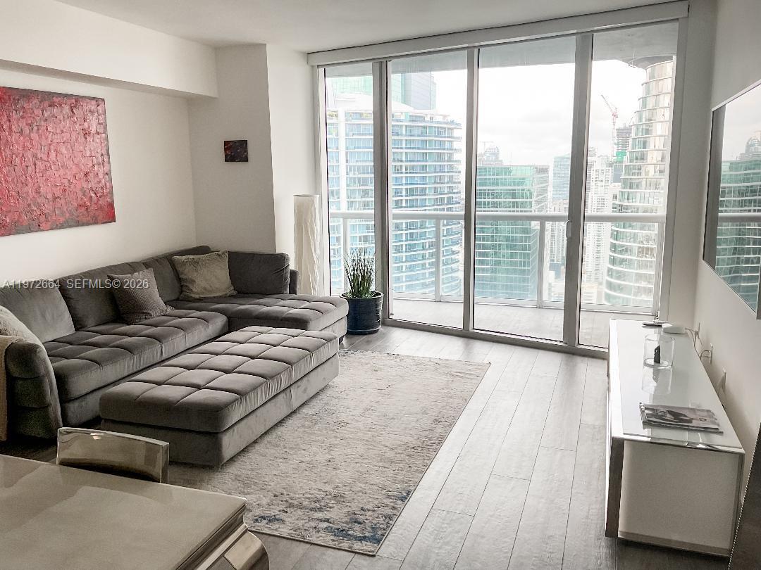475 Brickell Avenue, Unit 4910 Miami, FL 33131 - Photo 11 of 25 a living room with furniture and a floor to ceiling window