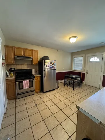 a kitchen with stainless steel appliances kitchen island granite countertop a refrigerator and a stove top oven