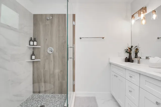 a bathroom with a shower sink and mirror