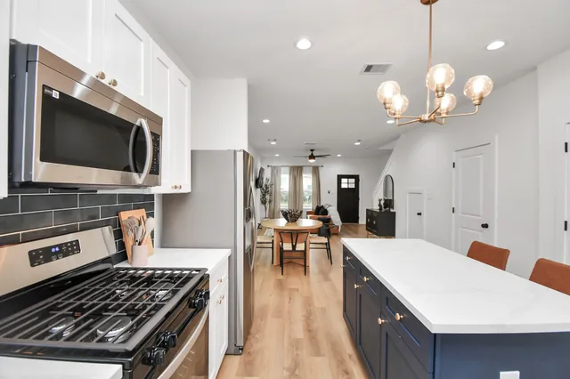a kitchen with a stove and a chandelier