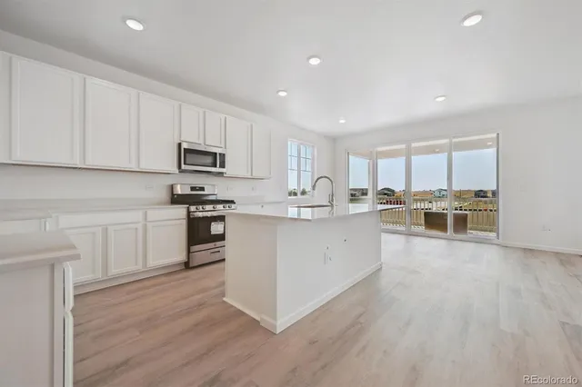 a kitchen with stainless steel appliances a refrigerator sink and microwave