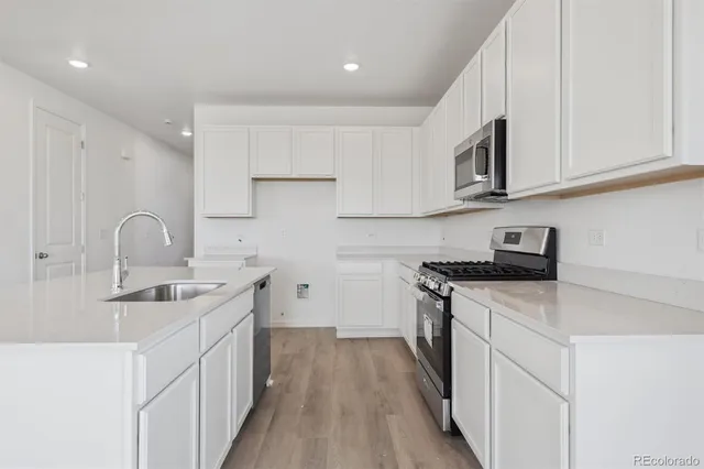 a kitchen with stainless steel appliances granite countertop a sink stove and cabinets