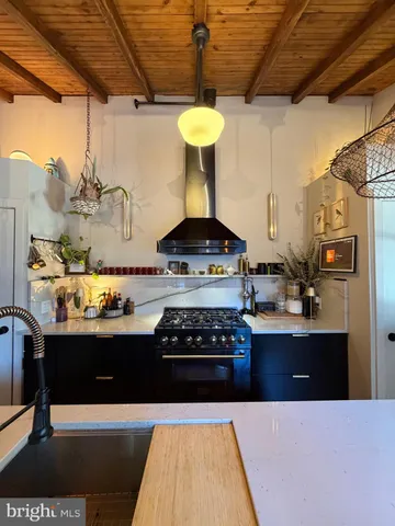 a kitchen with stainless steel appliances granite countertop a stove a refrigerator and a wooden cabinets