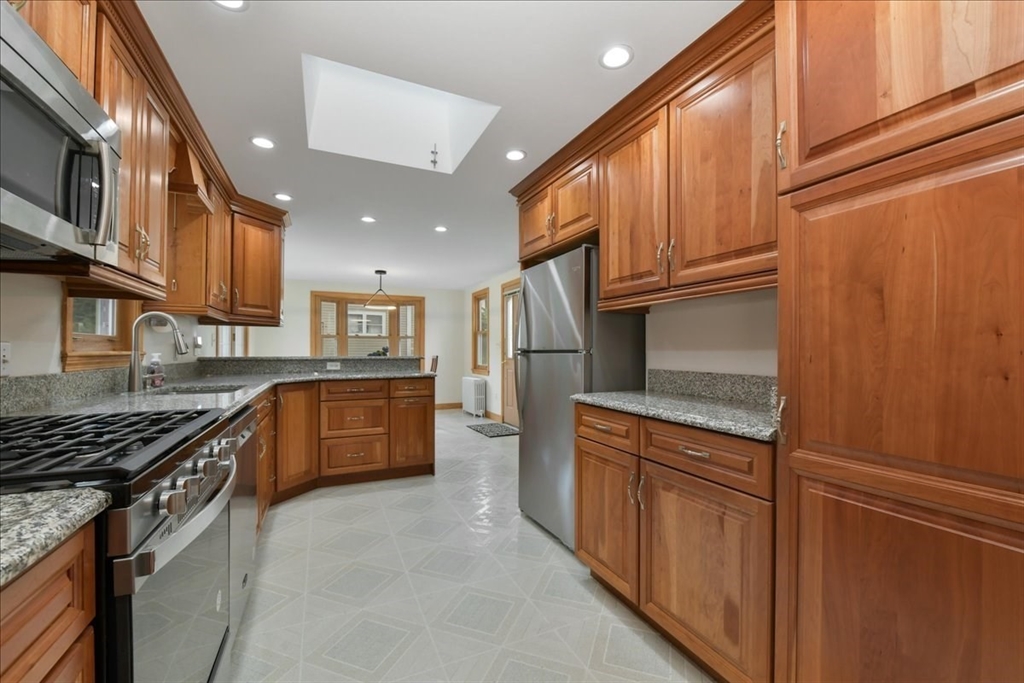 102 Border Street Dedham, MA 02026 - Photo 12 of 34 a kitchen with stainless steel appliances granite countertop a stove a sink and a refrigerator