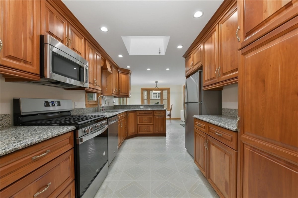 102 Border Street Dedham, MA 02026 - Photo 13 of 34 a kitchen with stainless steel appliances granite countertop a stove a sink and a microwave