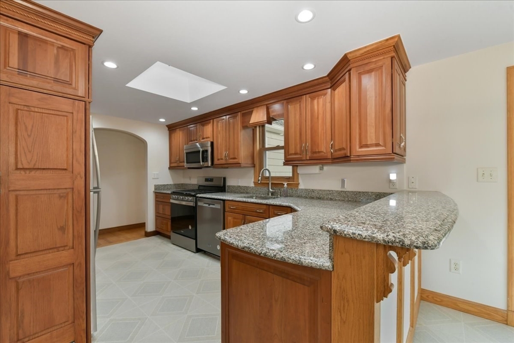 102 Border Street Dedham, MA 02026 - Photo 14 of 34 a kitchen with stainless steel appliances granite countertop a sink stove refrigerator and cabinets