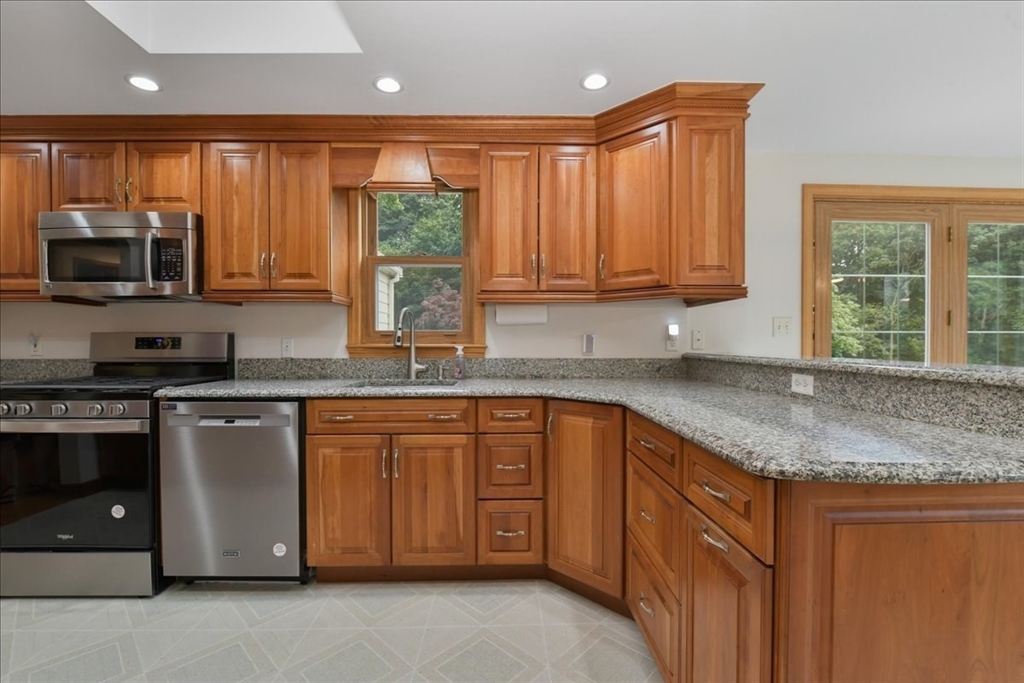 102 Border Street Dedham, MA 02026 - Photo 2 of 34 a kitchen with stainless steel appliances granite countertop a stove a sink and a microwave