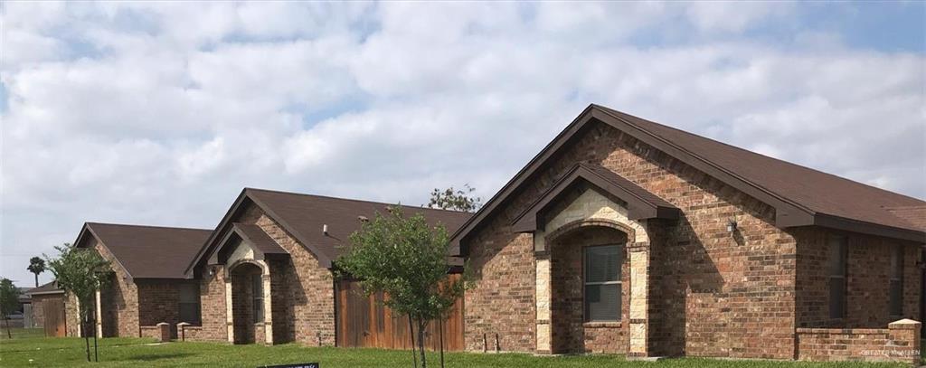 View of front facade with brick siding and a front yard