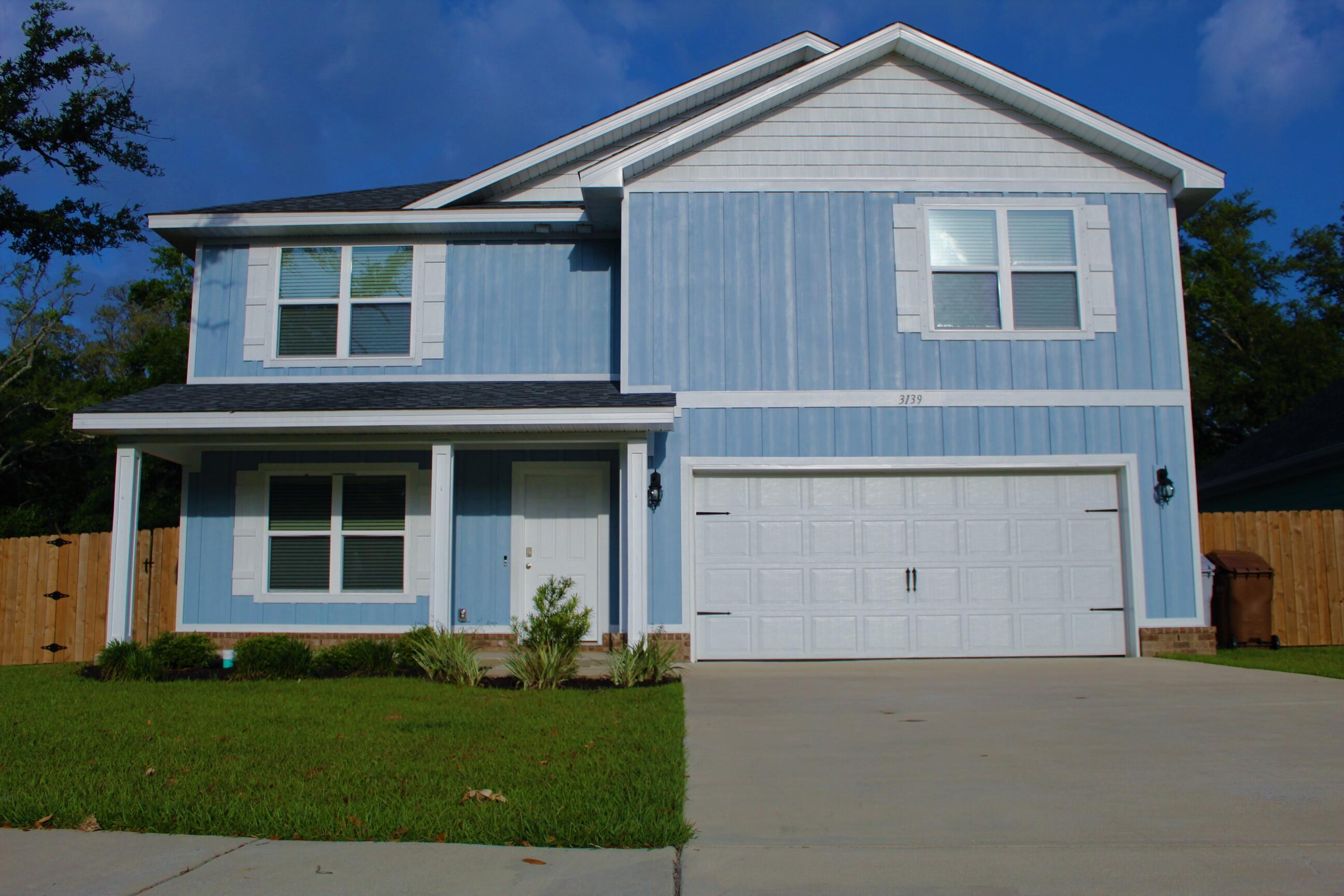 3139 Heritage Oaks Circle Navarre, FL 32566 - Photo 1 of 34 a front view of a house with garden