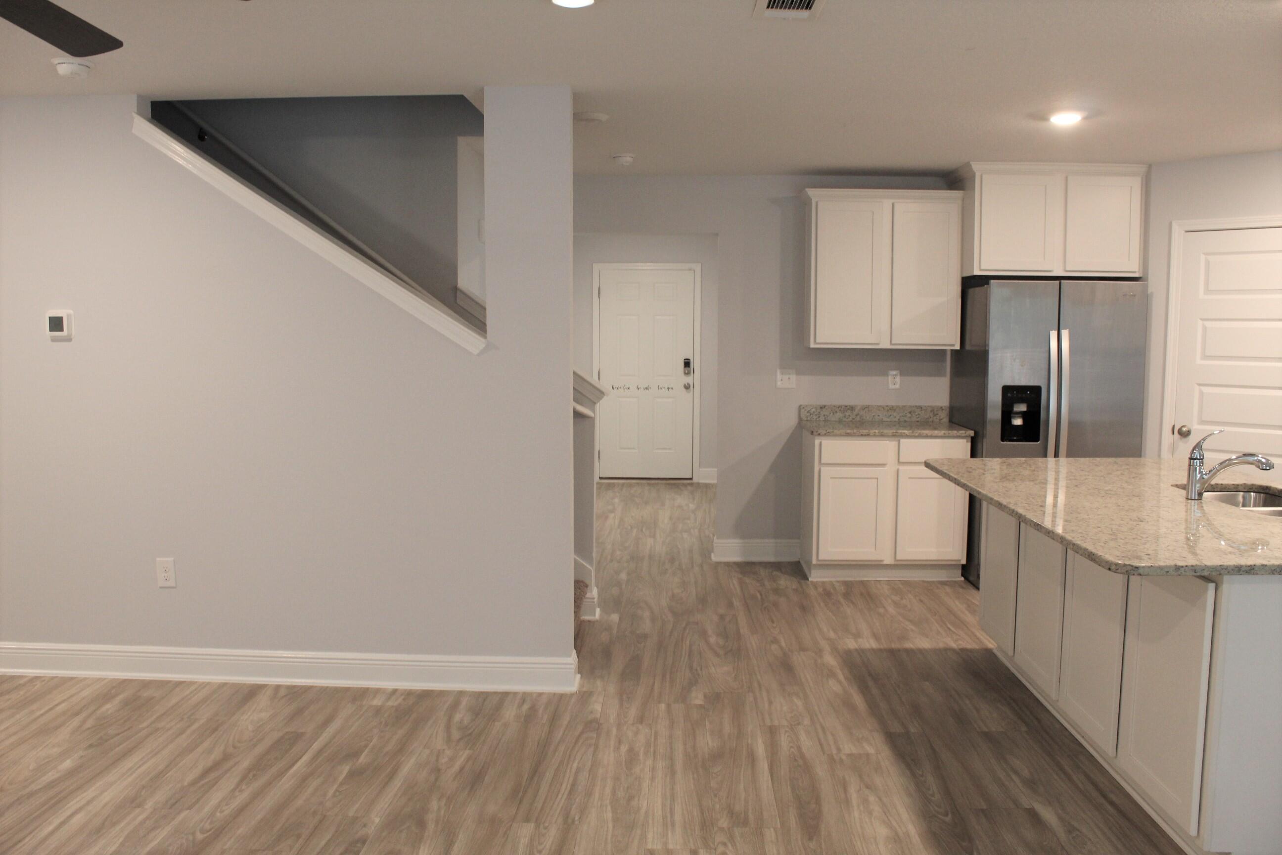 3139 Heritage Oaks Circle Navarre, FL 32566 - Photo 11 of 34 a kitchen with a sink a refrigerator a microwave and cabinets