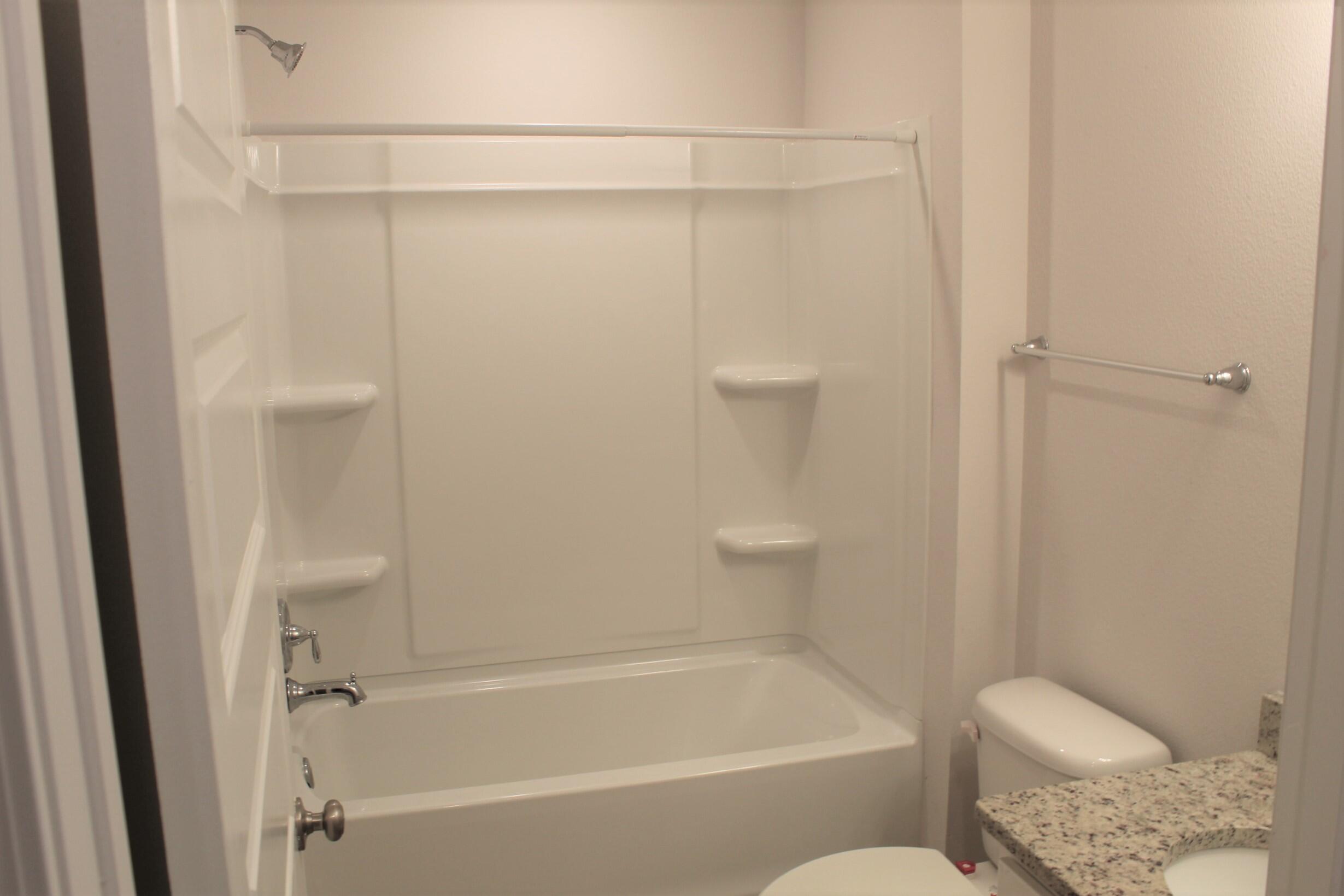 3139 Heritage Oaks Circle Navarre, FL 32566 - Photo 15 of 34 a bathroom with a granite countertop bathtub shower and toilet