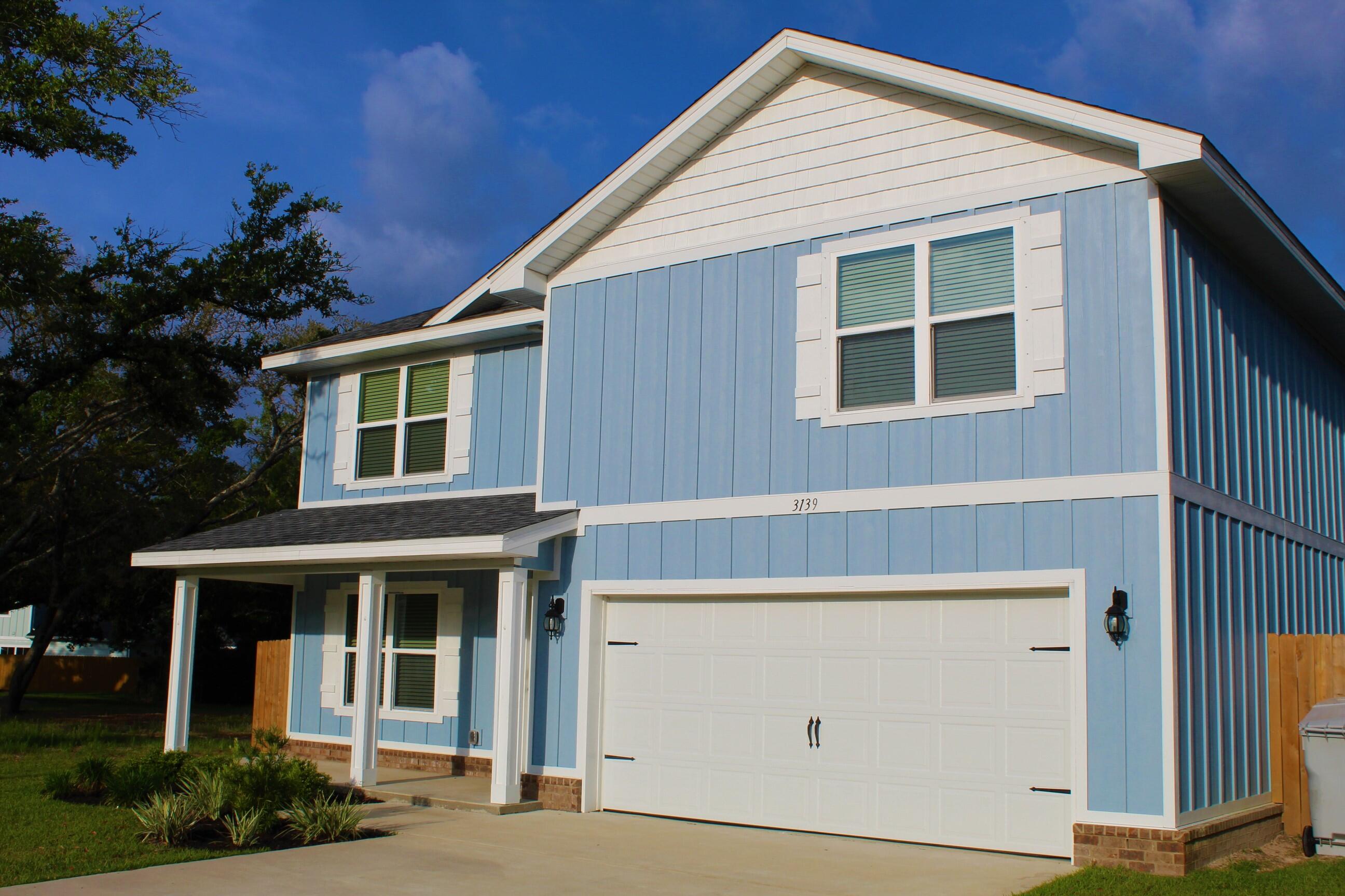 3139 Heritage Oaks Circle Navarre, FL 32566 - Photo 2 of 34 a front view of a house with plants