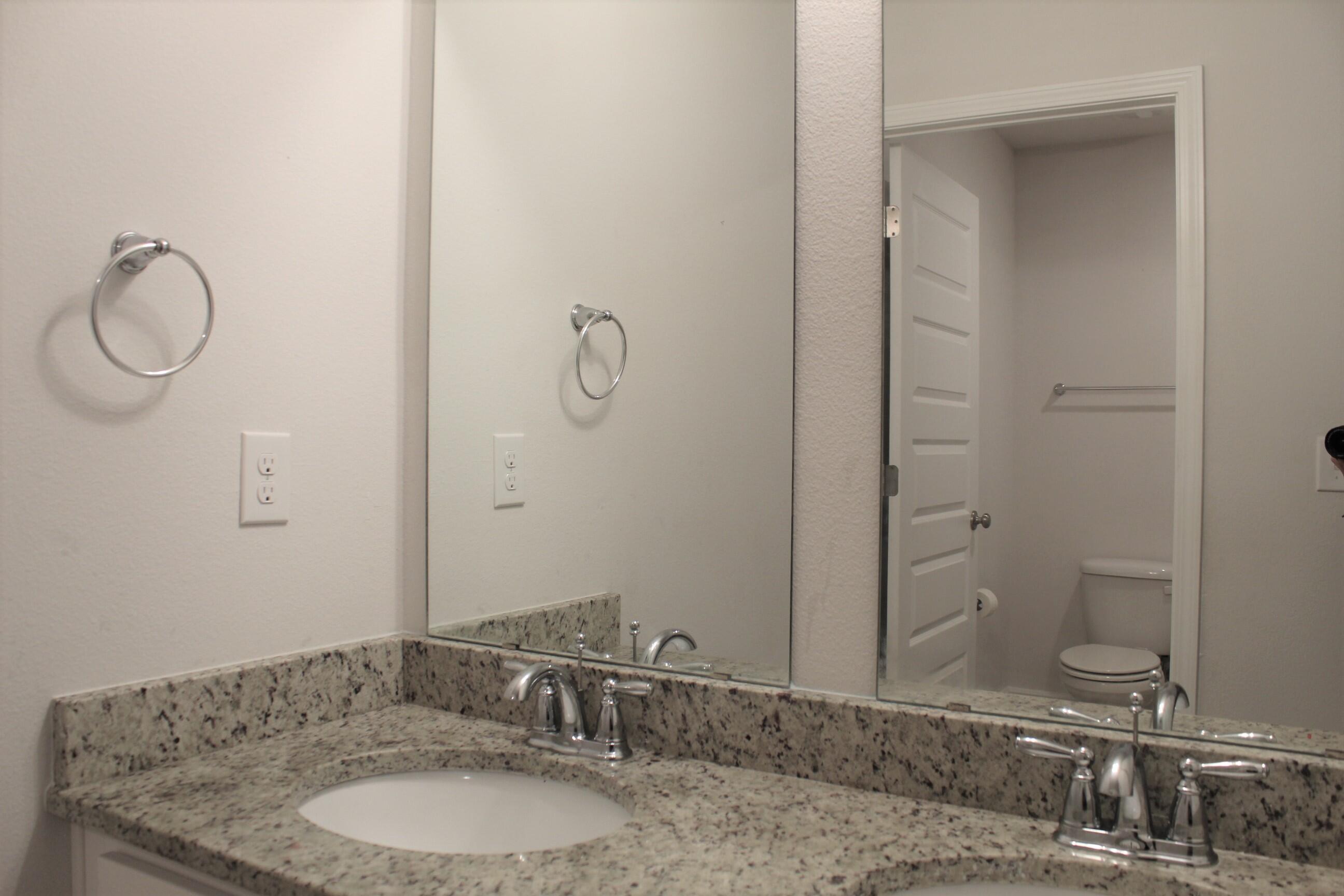 3139 Heritage Oaks Circle Navarre, FL 32566 - Photo 27 of 34 a bathroom with a granite countertop sink and a mirror