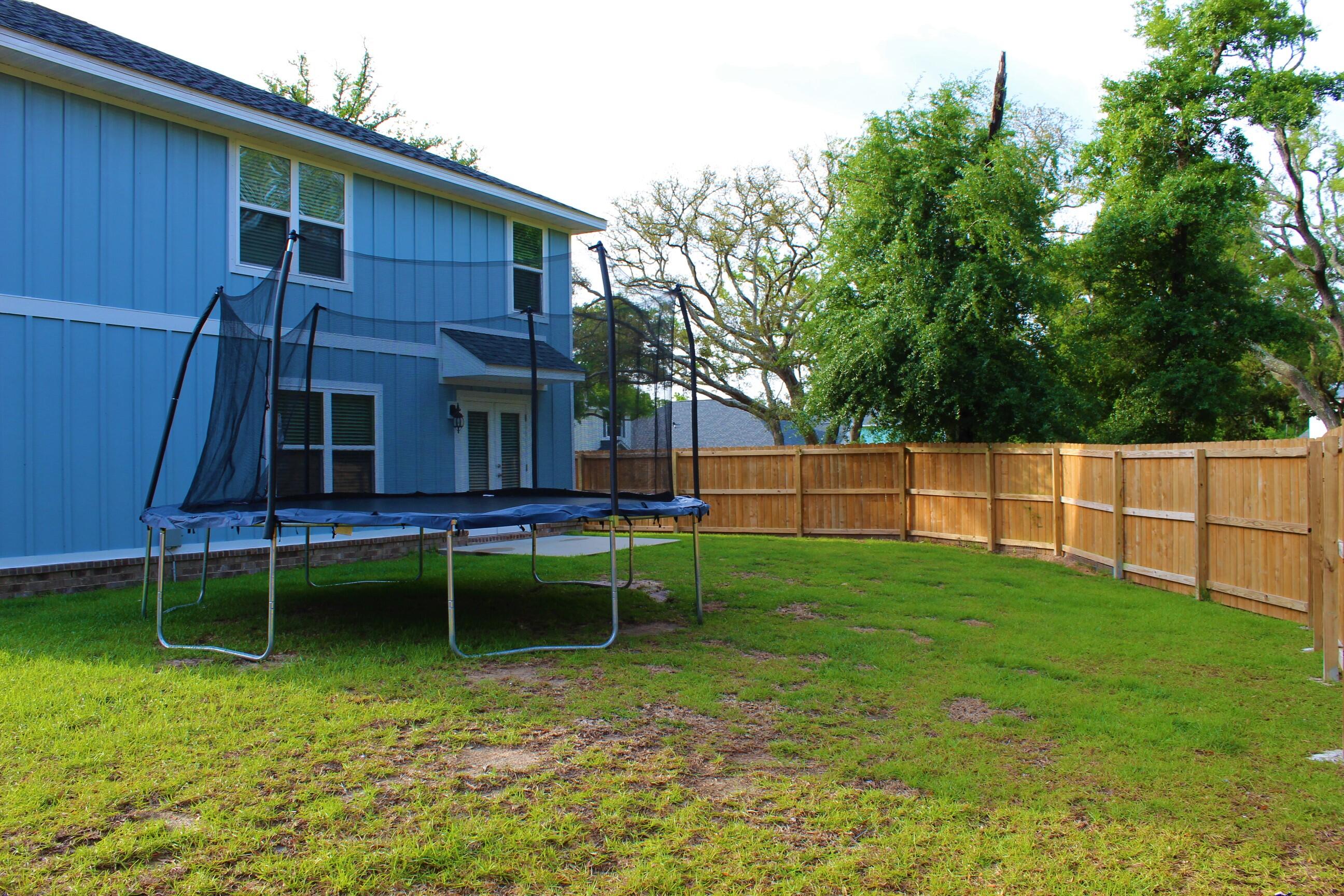 3139 Heritage Oaks Circle Navarre, FL 32566 - Photo 31 of 34 a view of backyard with wooden fence and a large tree