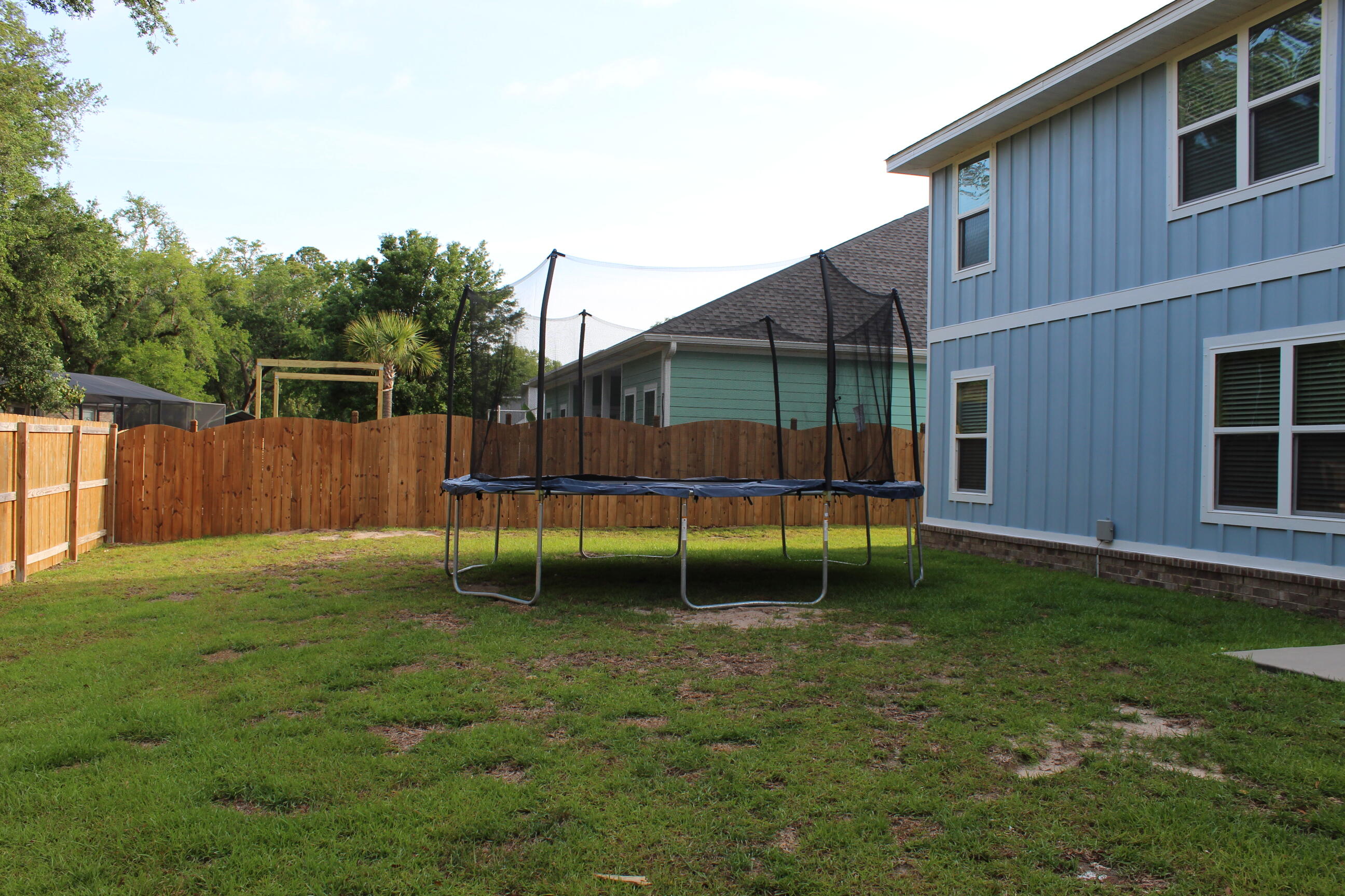 3139 Heritage Oaks Circle Navarre, FL 32566 - Photo 33 of 34 a backyard of a house with trampoline