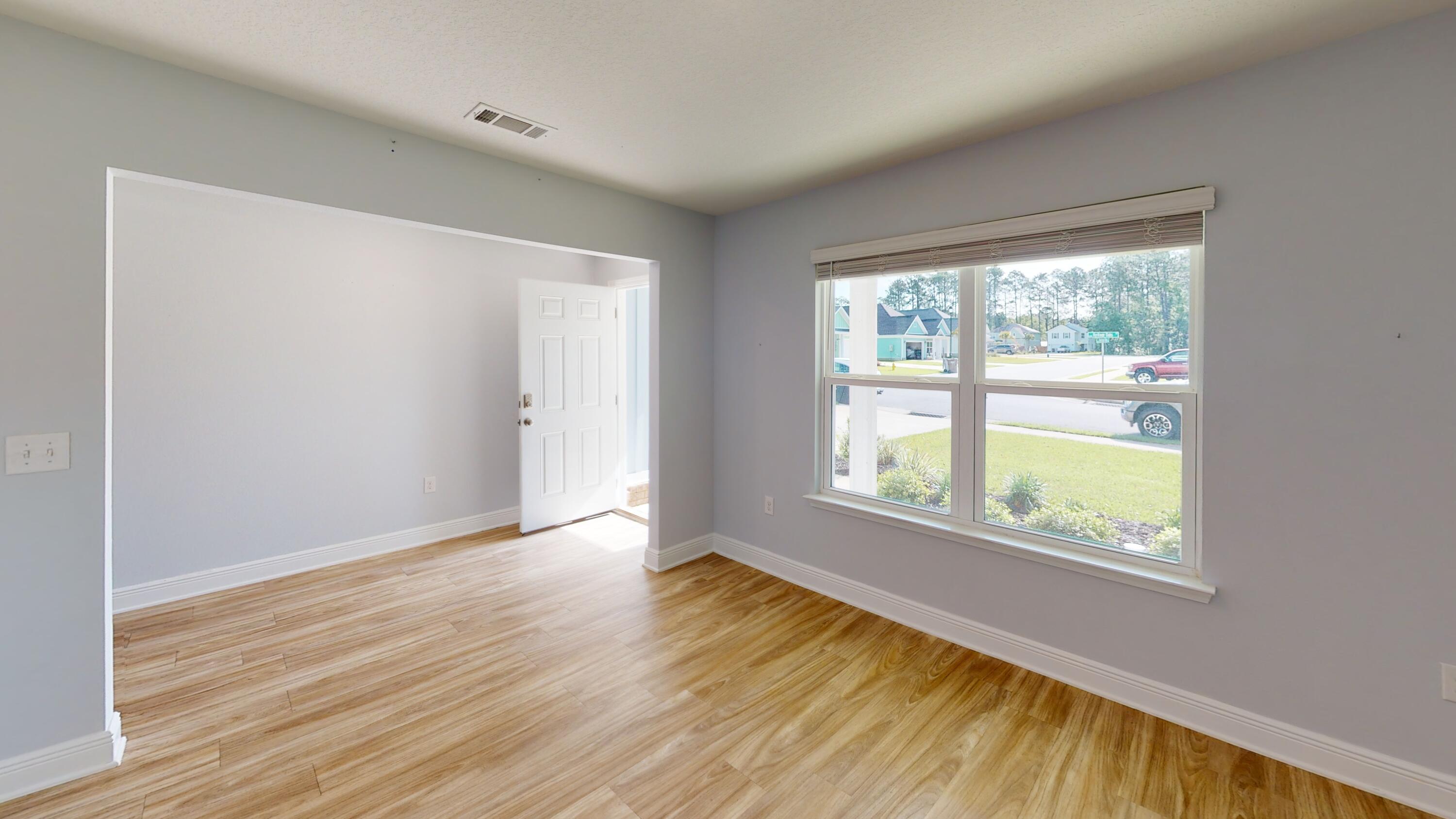 3139 Heritage Oaks Circle Navarre, FL 32566 - Photo 5 of 34 a view of an empty room with wooden floor and a window