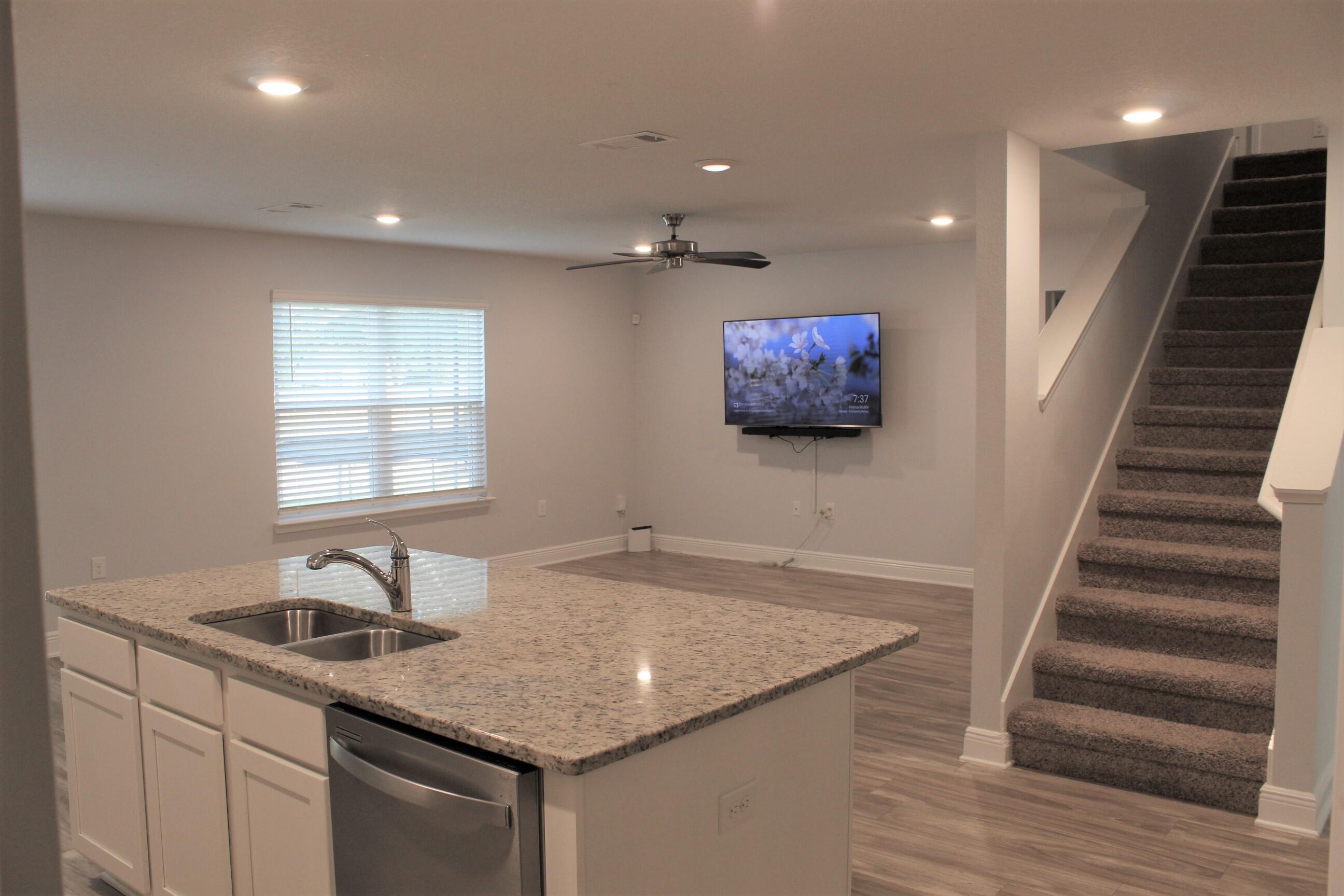 3139 Heritage Oaks Circle Navarre, FL 32566 - Photo 7 of 34 a kitchen with sink cabinets and a wooden floor