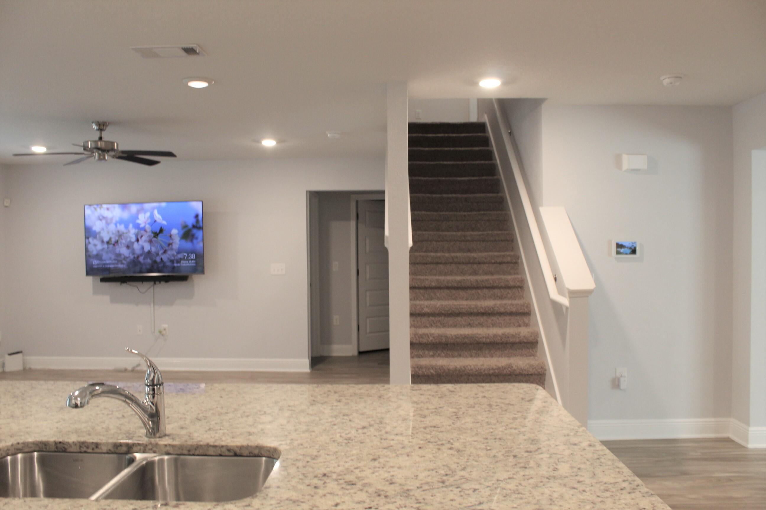 3139 Heritage Oaks Circle Navarre, FL 32566 - Photo 8 of 34 a view of a livingroom with wooden floor and staircase