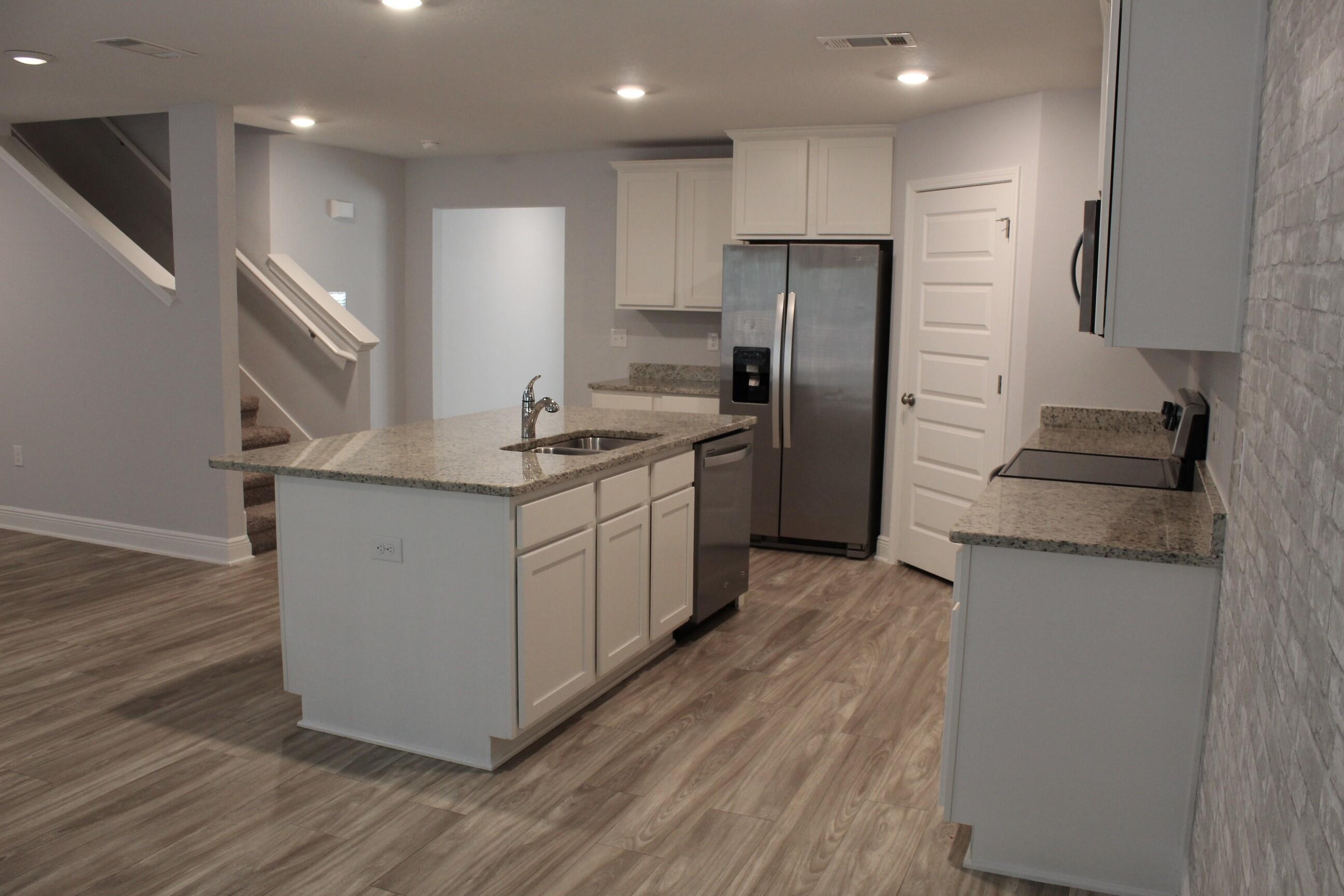 3139 Heritage Oaks Circle Navarre, FL 32566 - Photo 9 of 34 a kitchen with stainless steel appliances granite countertop a refrigerator a sink and a stove