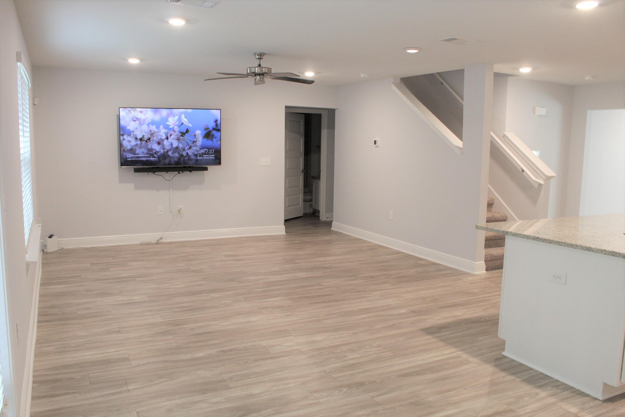 3139 Heritage Oaks Circle Navarre, FL 32566 - Photo 10 of 34 an empty room with wooden floor and windows
