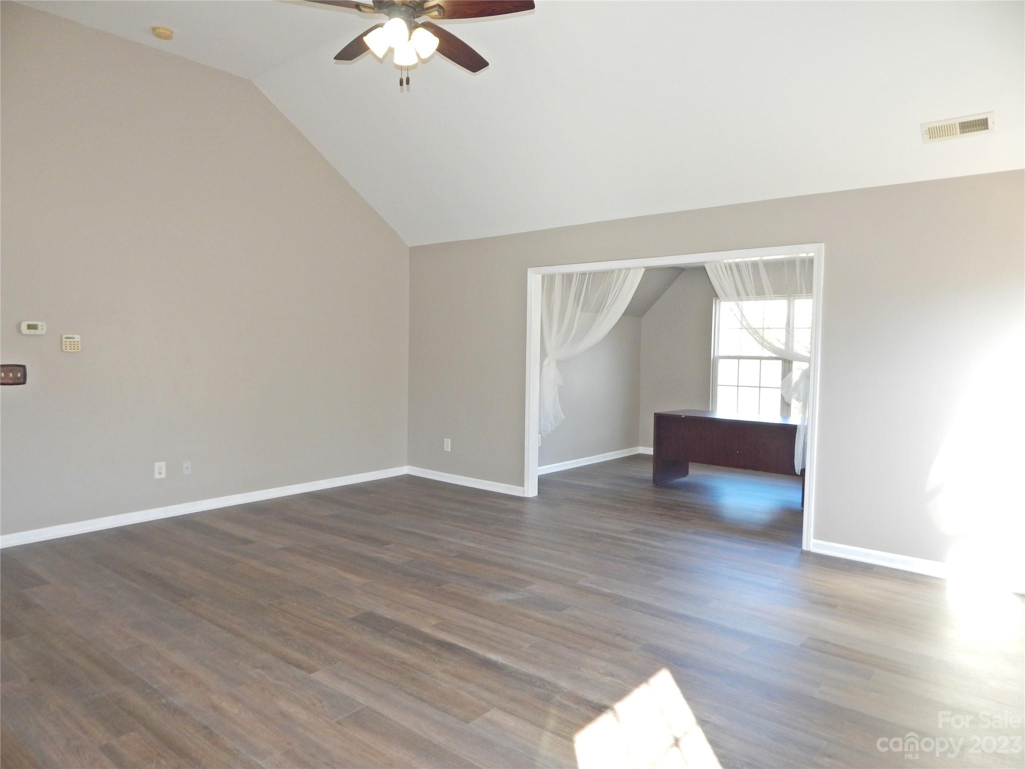 651 Fall Line Way Rock Hill, SC 29730 - Photo 14 of 25 an empty room with wooden floor chandelier fan and windows