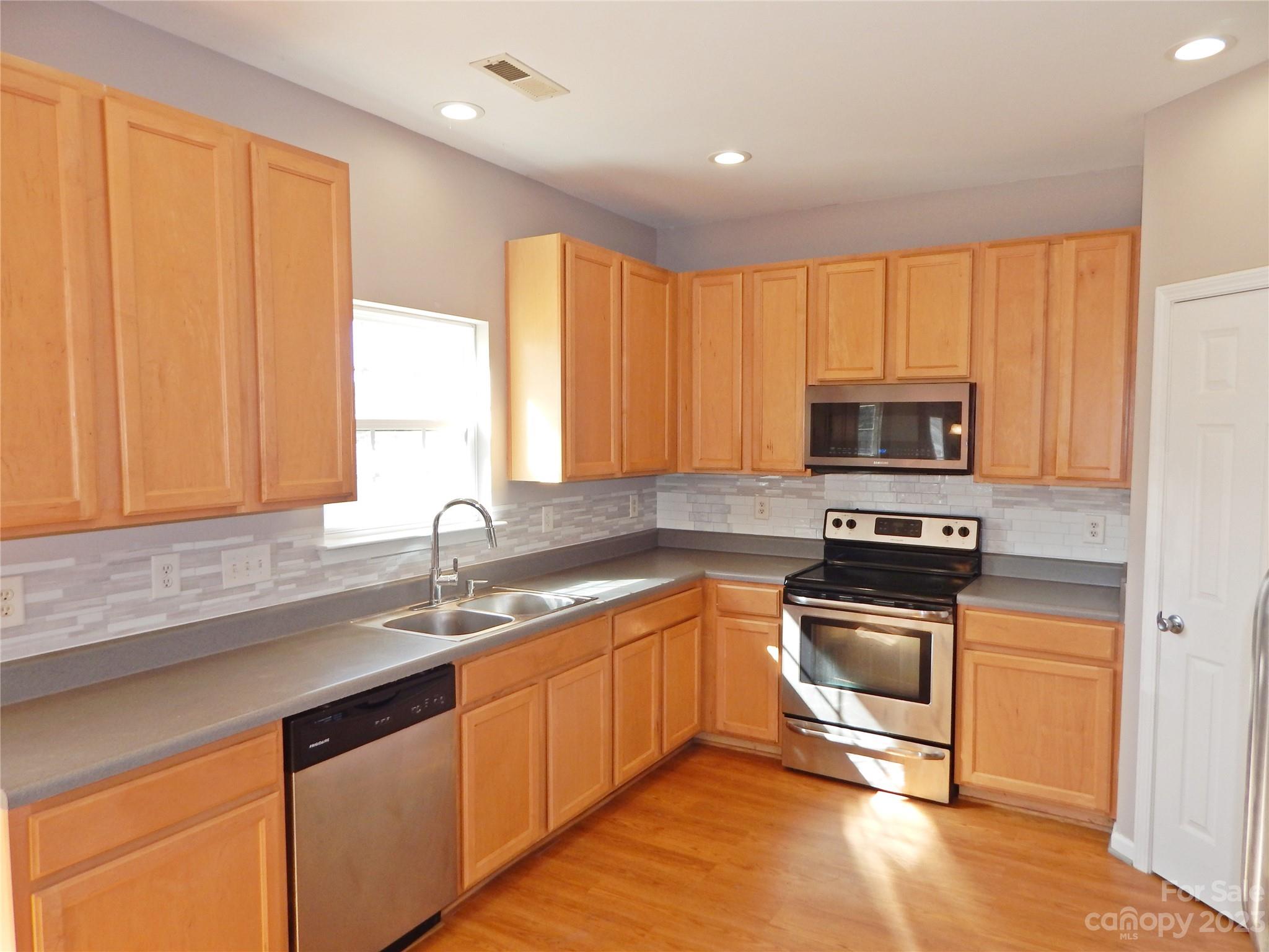 651 Fall Line Way Rock Hill, SC 29730 - Photo 9 of 25 a kitchen with stainless steel appliances granite countertop a sink a stove a microwave and cabinets
