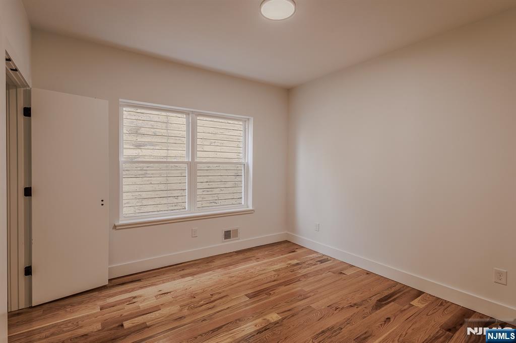 29 Kent Street Newark, NJ 07108 - Photo 12 of 30 an empty room with wooden floor and window
