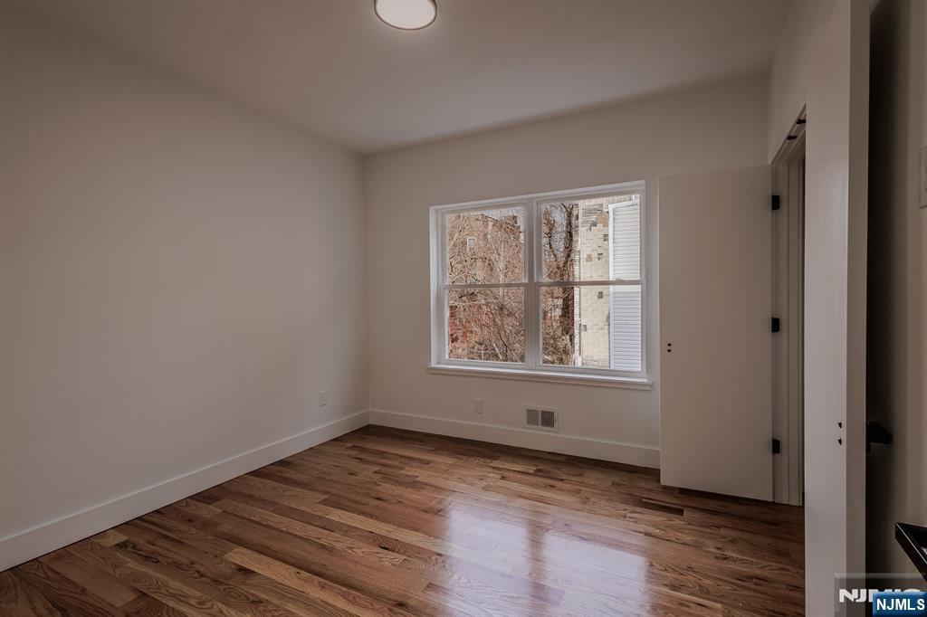 29 Kent Street Newark, NJ 07108 - Photo 16 of 30 an empty room with wooden floor and windows