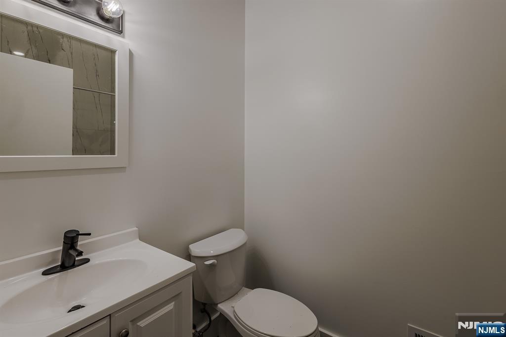 29 Kent Street Newark, NJ 07108 - Photo 21 of 30 a bathroom with a sink a toilet and mirror