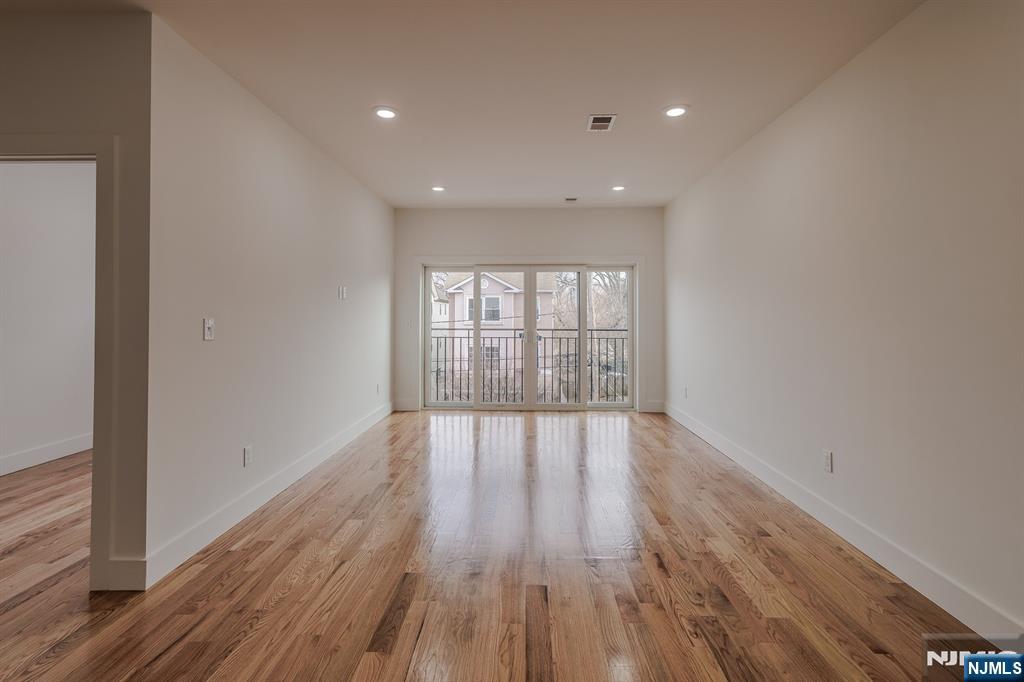 29 Kent Street Newark, NJ 07108 - Photo 27 of 30 a view of an empty room with wooden floor and a window