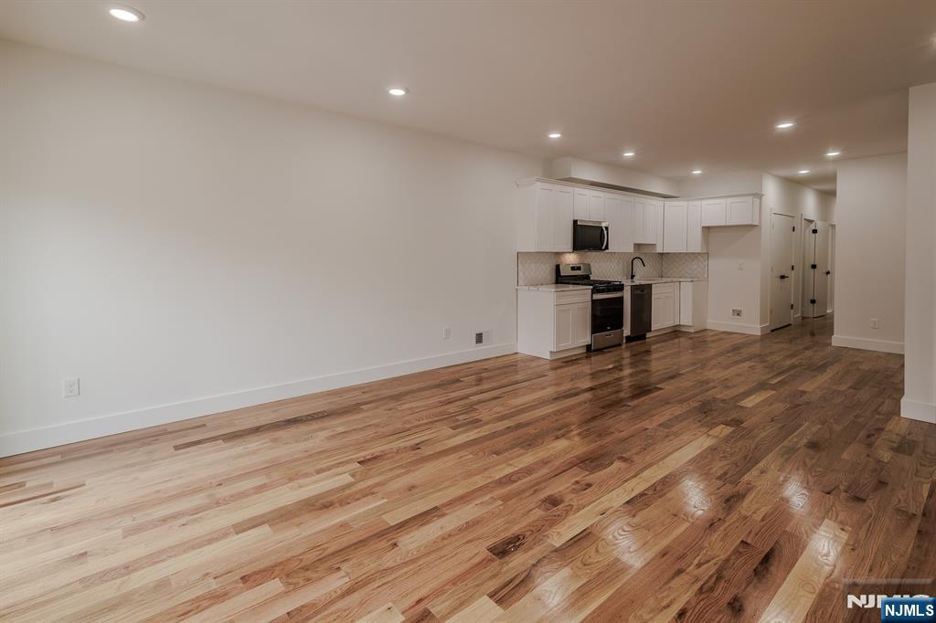 29 Kent Street Newark, NJ 07108 - Photo 5 of 30 a view of a kitchen with a sink and a refrigerator