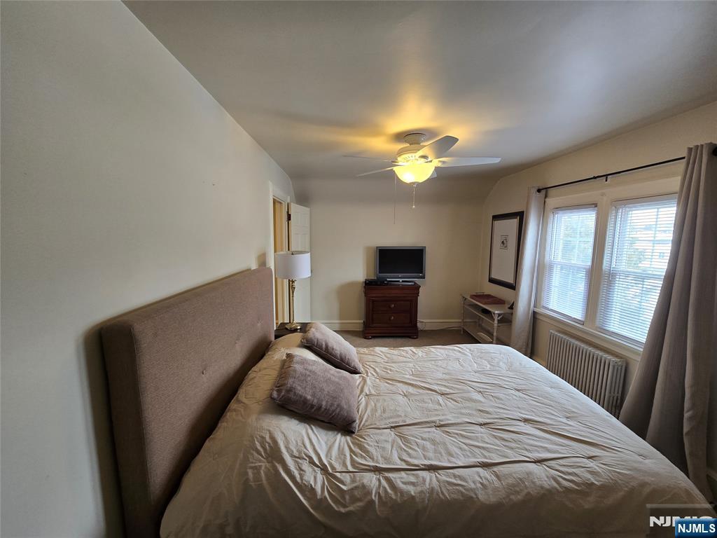224 Cleveland Avenue Hasbrouck Heights, NJ 07604 - Photo 17 of 29 a bedroom with a bed and a chandelier