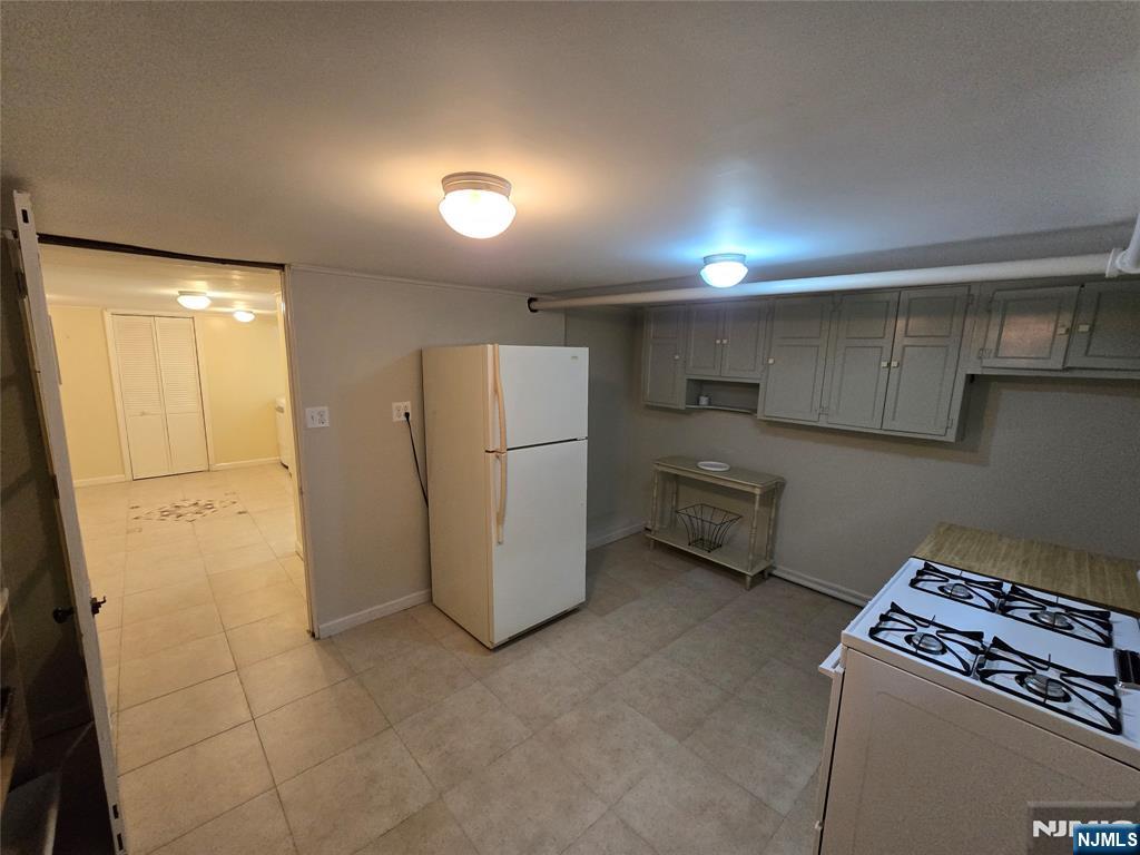 224 Cleveland Avenue Hasbrouck Heights, NJ 07604 - Photo 28 of 29 a kitchen with refrigerator and white cabinets