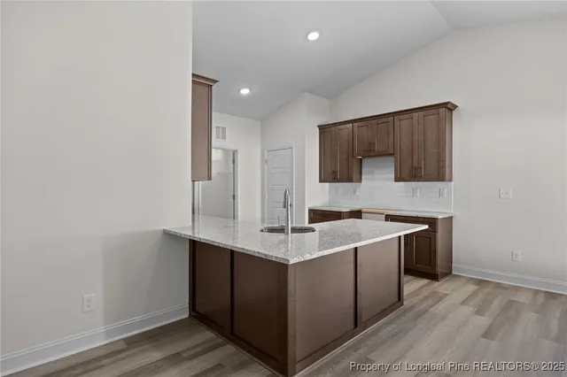 a kitchen with a sink cabinets and wooden floor