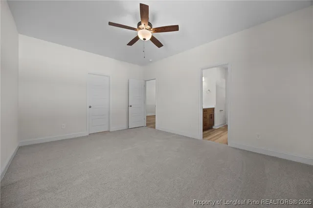 an empty room with ceiling fan and window