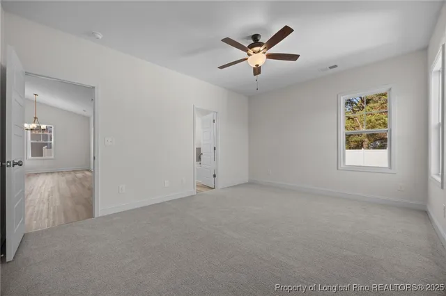 an empty room with windows and fan