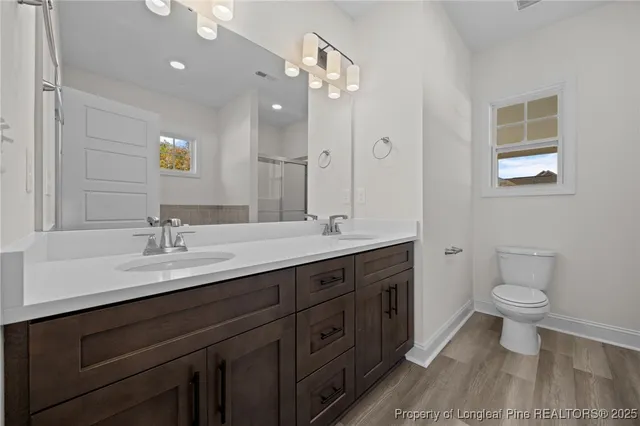 a bathroom with a toilet sink double vanity and mirror