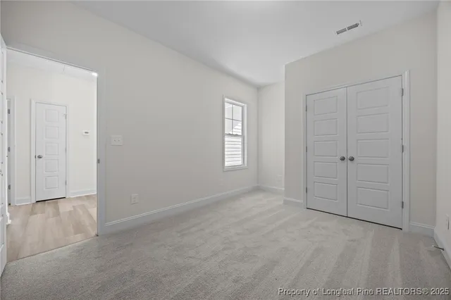 an empty room with windows and closet