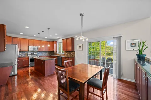 a view of a dining room and livingroom with furniture wooden floor a chandelier