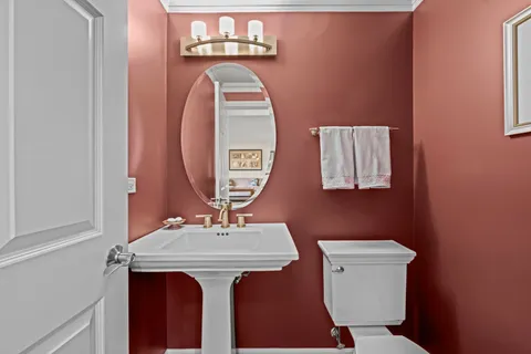 a bathroom with a toilet a sink and a mirror