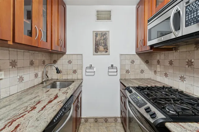 a kitchen with granite countertop a stove and a sink