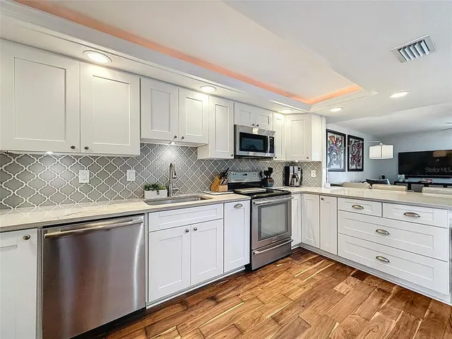 a kitchen with granite countertop cabinets stainless steel appliances and a window