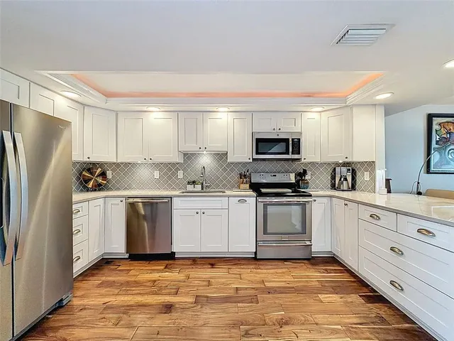 a kitchen with stainless steel appliances a refrigerator sink and cabinets