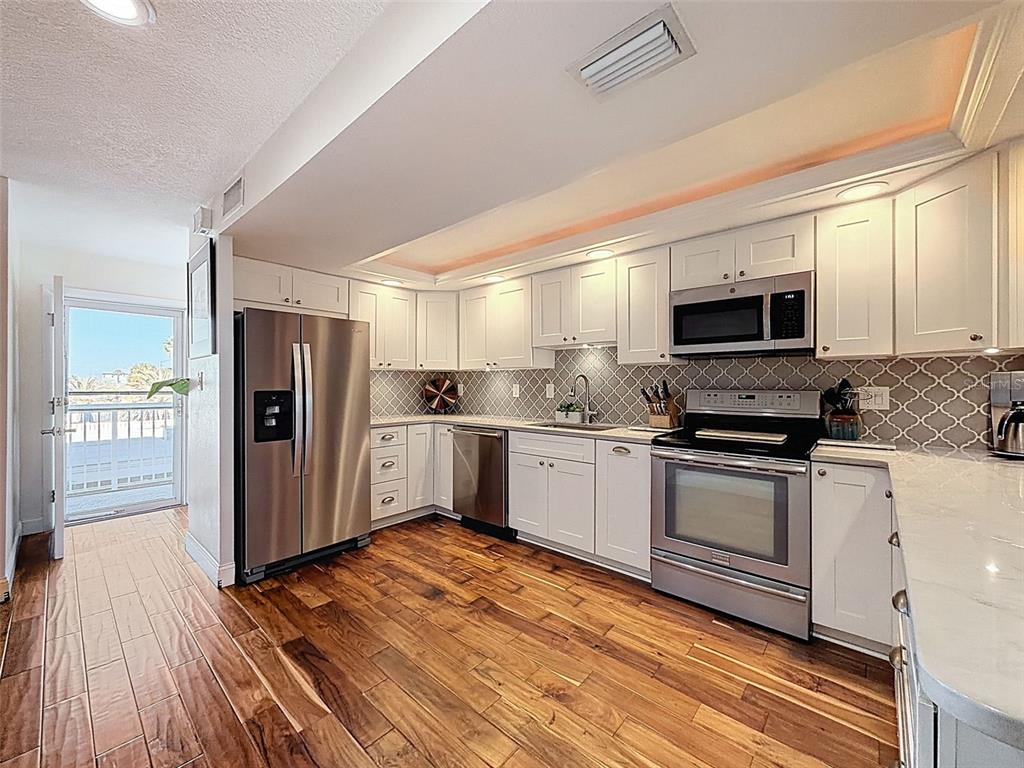 433 Paula Drive South, Unit 23 Dunedin, FL 34698 - Photo 13 of 56 a kitchen with stainless steel appliances granite countertop a refrigerator a stove top oven a sink and dishwasher