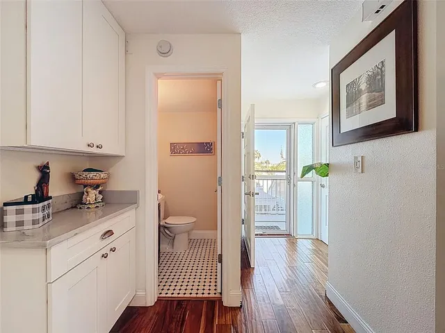 a view of a hallway to a room with wooden floor