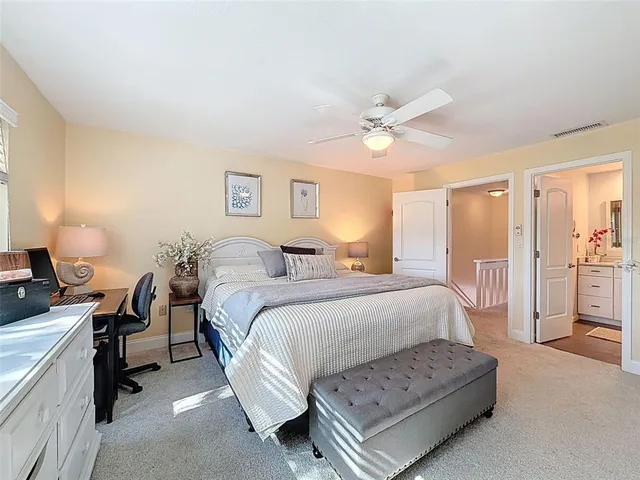 a bedroom with a bed a desk and chair with a bookshelf